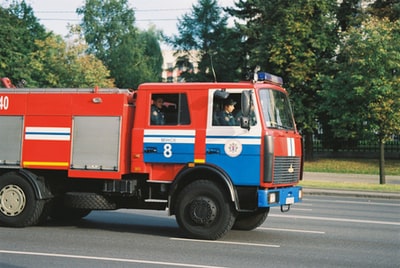 The red and blue bus on the road during the day
